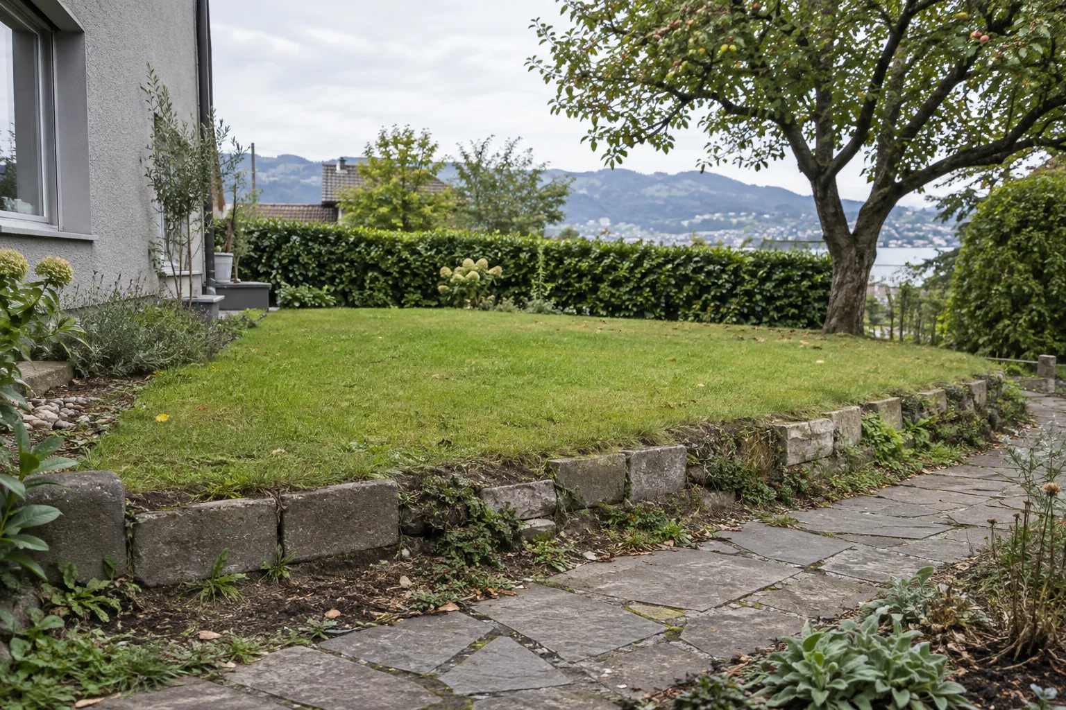 Niedrige Garteneinfassung aus unterschiedlich alten Betonsteinen